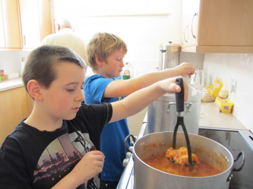 Two boys cooking a stew