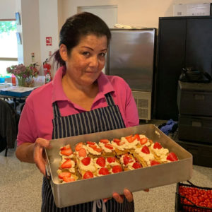 Woman carrying tray of strawberry slices