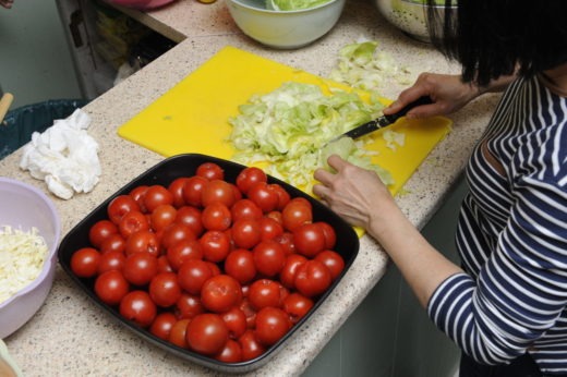 Woman chopping lettuce and tomatos